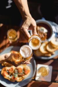 Friends taste seasonal beers beside a table with fall foods, clear glasses, and handwritten tasting notes.