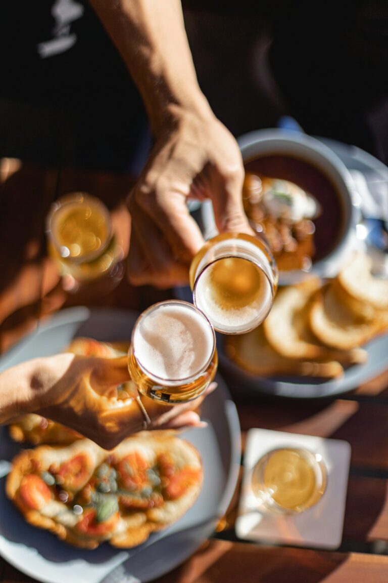 Friends taste seasonal beers beside a table with fall foods, clear glasses, and handwritten tasting notes.